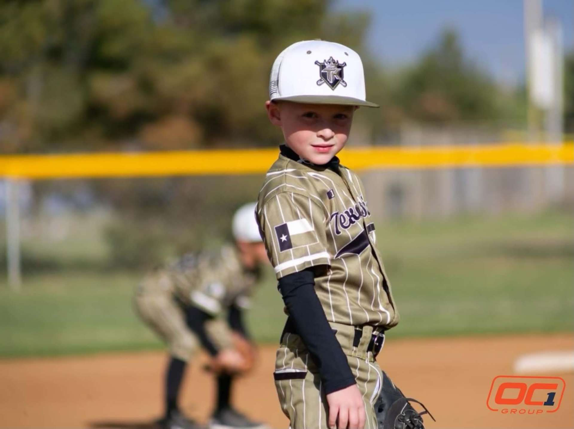 Youth travel baseball player in a custom pinstripe uniform on the field